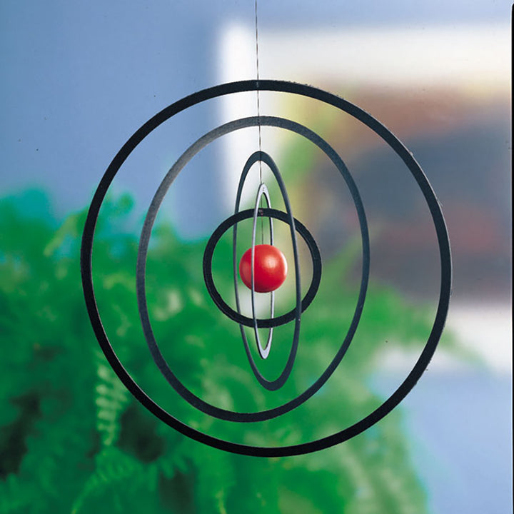The Science Fiction Mobile by Flensted features concentric black and silver rings with a red center ball, adding classic charm to any space.