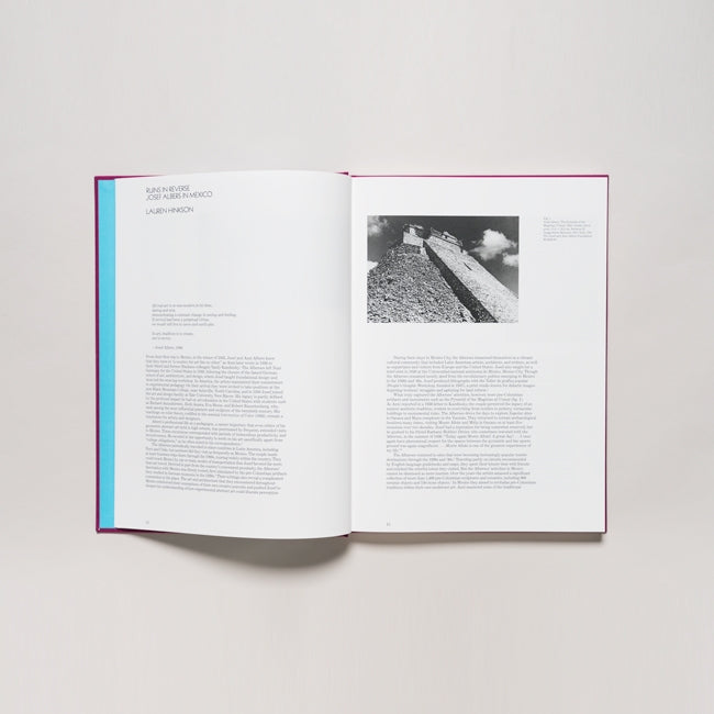 An open book, "Josef Albers in Mexico," shows text and blue on the left page. The right page features a black-and-white photo of a stone pathway with two people walking under a cloudy sky.