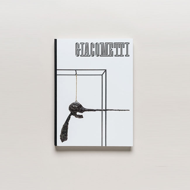 The book "Giacometti" features a white cover with a black sculpture suspended on a string inside a simple line-drawn box, highlighting the figurative sculptures of Alberto Giacometti.
