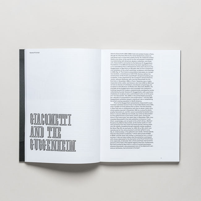 An open book titled "Giacometti" rests on a white surface. The left page highlights the modern master known for his figurative sculptures, while the right contains a dense block of small text.