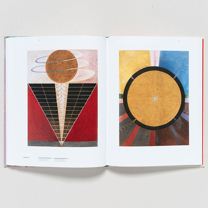 An open book, Hilma af Klint: Paintings for the Future, shows a large brown circle, rings, and a lined triangle on the left page; the right has a bold gold circle centered on radiating dark and colorful segments.