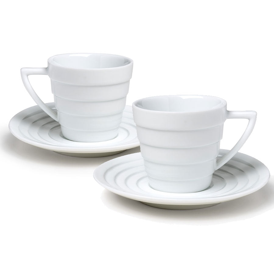 The Guggenheim Spiral Espresso Cup Set features two white porcelain Mid-century Modern cups with handles, each on a matching saucer decorated with concentric circles, displayed against a white background.