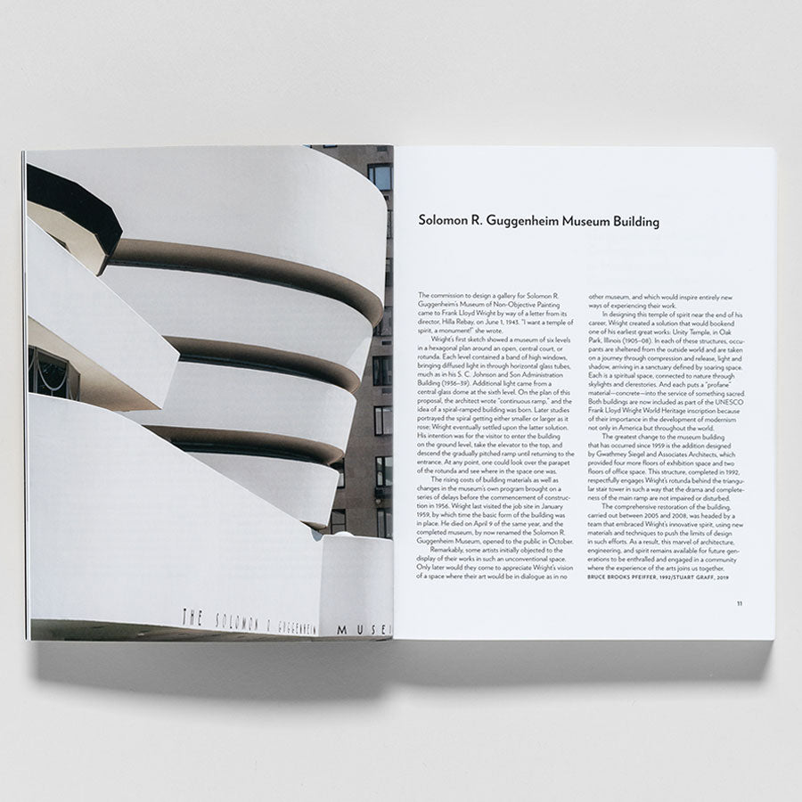 An open copy of Guggenheim Museum Collection: A to Z (revised edition) shows a photo of the Solomon R. Guggenheim Museum’s curved white exterior on one page and an article by Nancy Spector with title and text on the other.