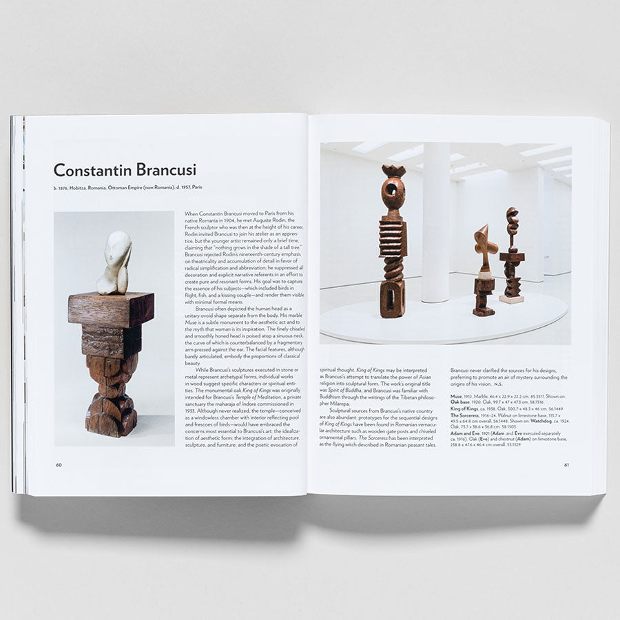 An open book, "Guggenheim Museum Collection: A to Z (revised edition)", shows a page on Constantin Brancusi with text and photos of his wood sculptures—one on the left page, three in a white gallery setting on the right. Curated by Vivien Greene.
