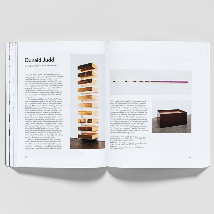 An open copy of "Guggenheim Museum Collection: A to Z (revised edition)" shows a Donald Judd spread with text and a photo of a stacked wooden sculpture on the left and minimalist wall installation and box sculpture on the right.