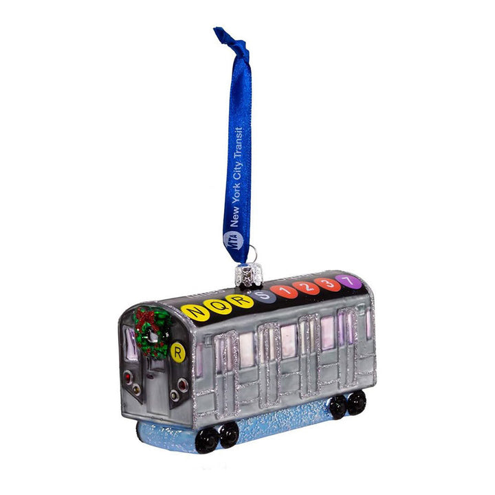 The MTA NYC Glass Subway Car Ornament is a 4.5-inch painted glass ornament shaped like a silver subway train, featuring route symbols on top, a blue New York City Transit ribbon, and a wreath with an R route sign on the front.