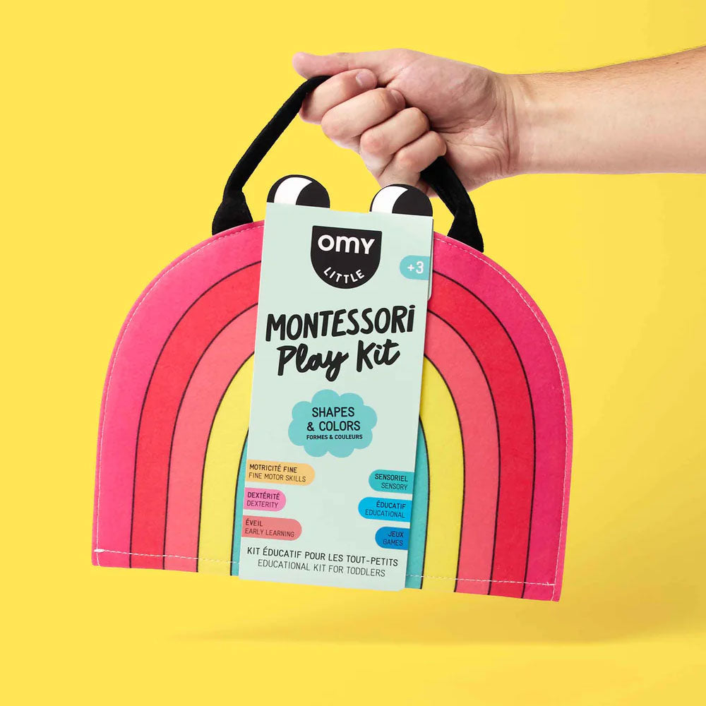 A hand holds the Guggenheim Museum Rainbow Montessori Play Kit, boosting toddler cognitive skills on a yellow backdrop.