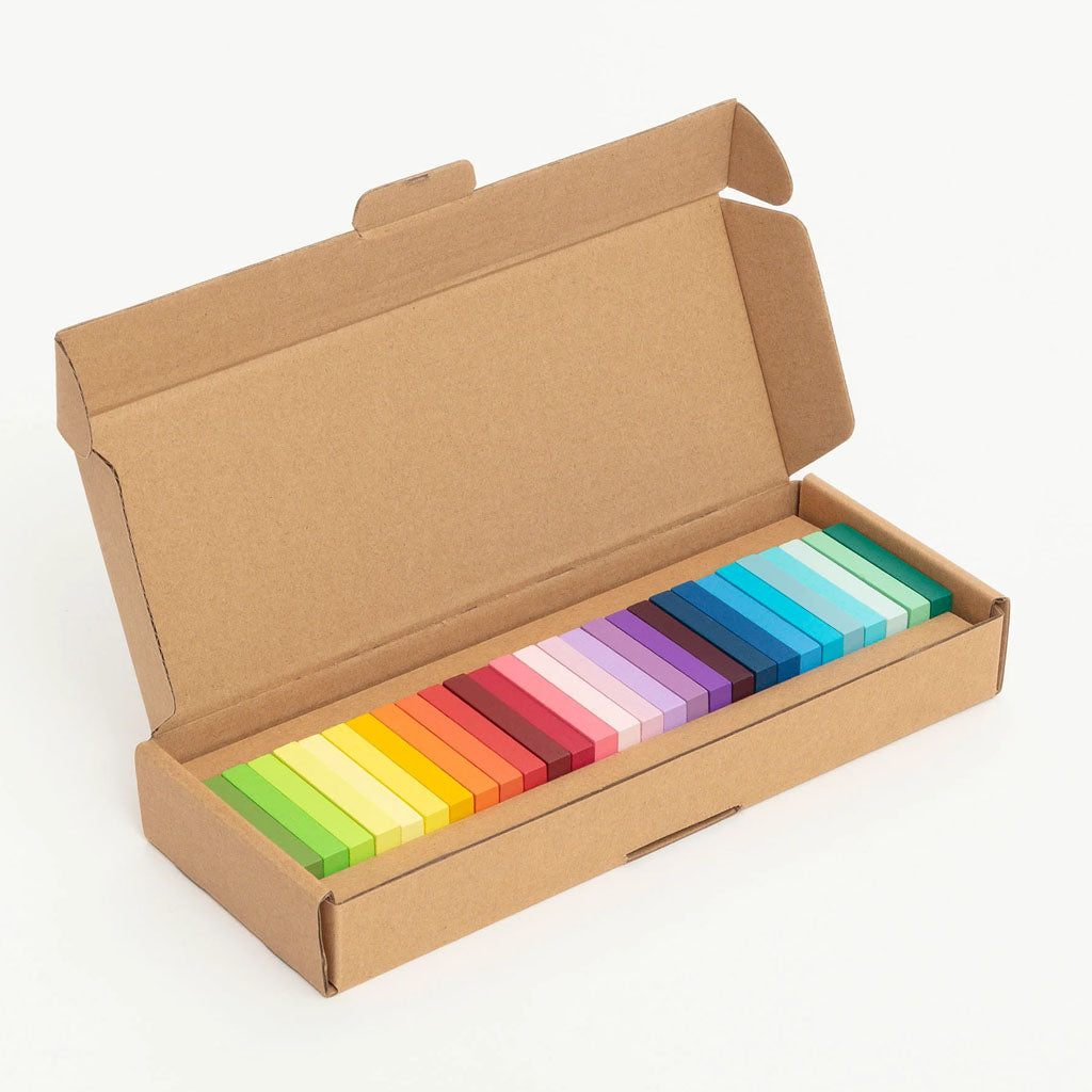 Open box of Guggenheim Museum Gradient Dominoes, arranged in a colorful yellow-to-blue gradient.