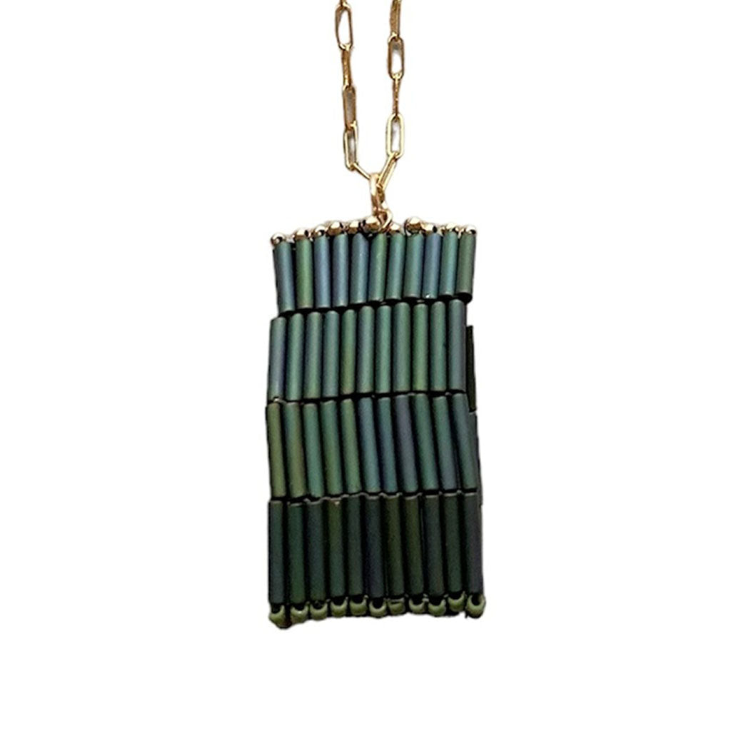 The Trecy Bleich Rice Stack Necklace Moss showcases iridescent green tube beads in three uneven, vertical rows on a gold elongated-link chain—a handcrafted piece from our Rice collection.
