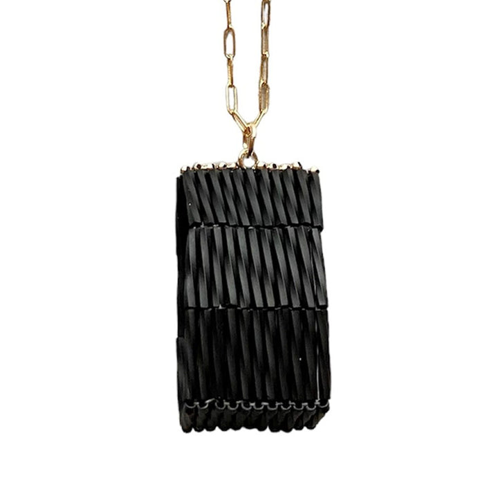 The Trecy Bleich Rice Stack Necklace Charcoal features a handcrafted gold chain and a rectangular black, ridged pendant—a striking piece from our Rice collection.