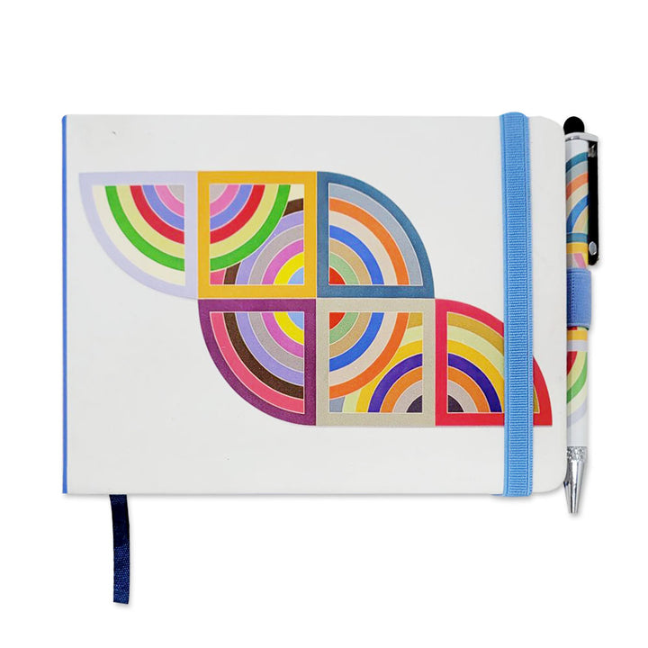 The Stella, Harran II Notebook is a white journal with colorful overlapping half-circles and squares, featuring a light blue elastic band and matching pen—ideal for taking notes in style.