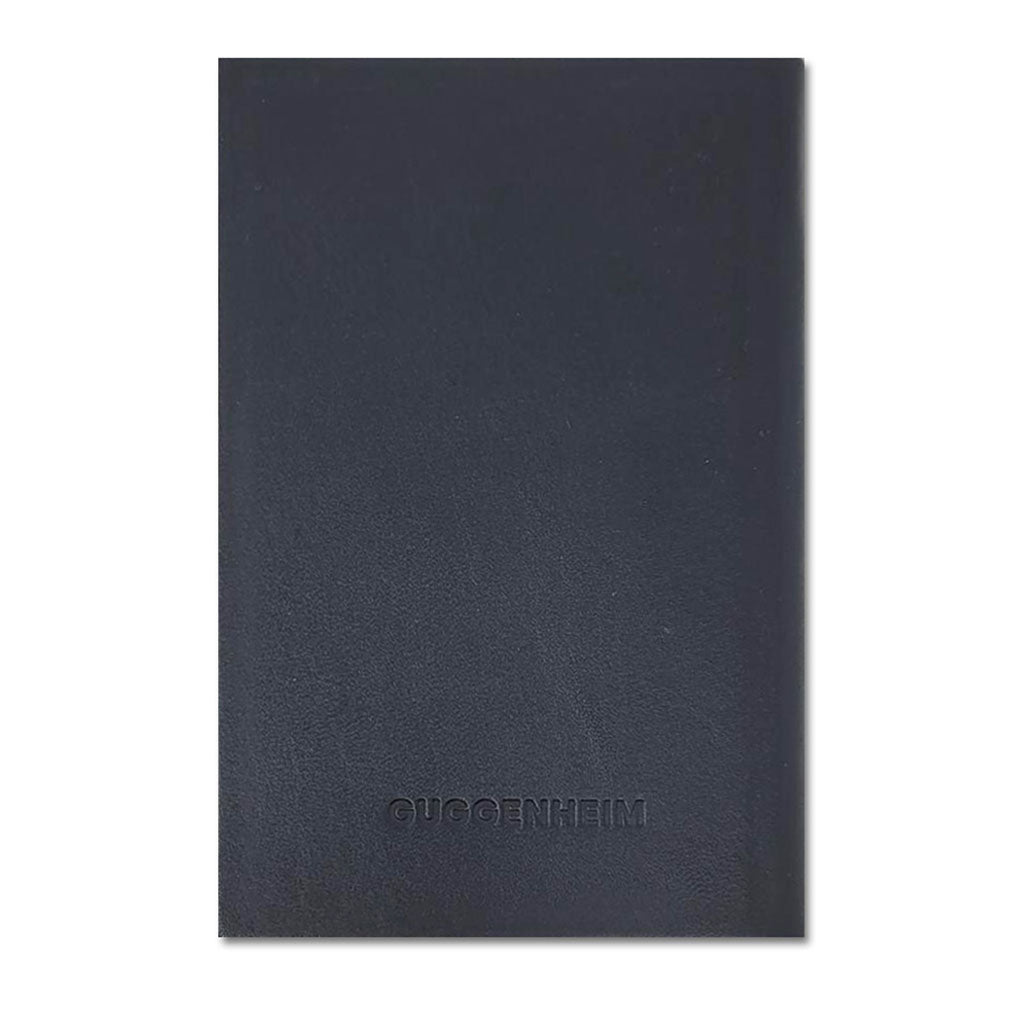 The Guggenheim Leather Notebook is a plain black leather-bound notebook with "GUGGENHEIM" embossed at the lower center of the front cover, set against a white background.