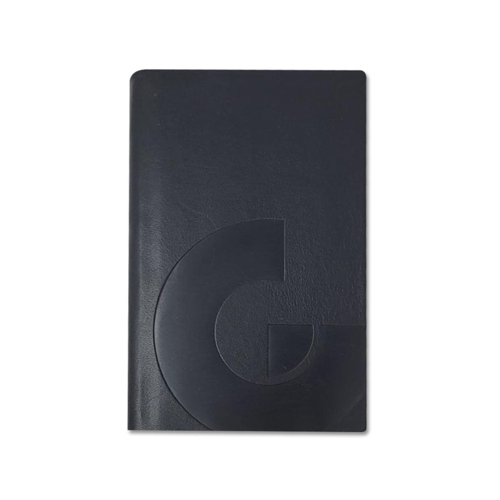 The Guggenheim Leather Pocket Notebook is a closed black notebook featuring a glossy, embossed geometric "G" design on the cover, shown against a white background.