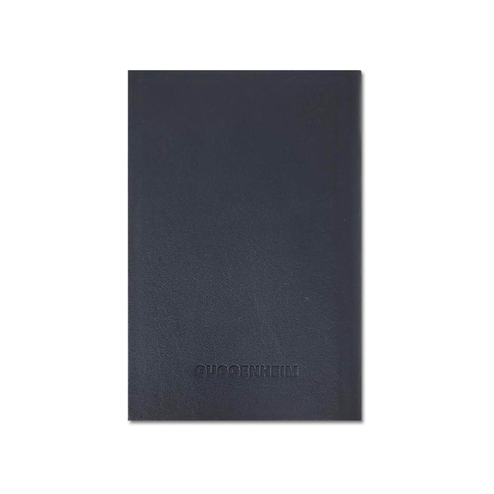 A closed Guggenheim Leather Pocket Notebook, plain black with GUGGENHEIM embossed in uppercase on the centered front cover, is shown against a white background.
