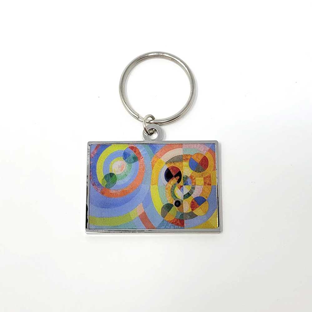 The Delaunay, Circular Forms Keychain features a rectangular shape with a metal ring and an abstract geometric design of overlapping circles in blue, yellow, red, green, and orange on a white background.