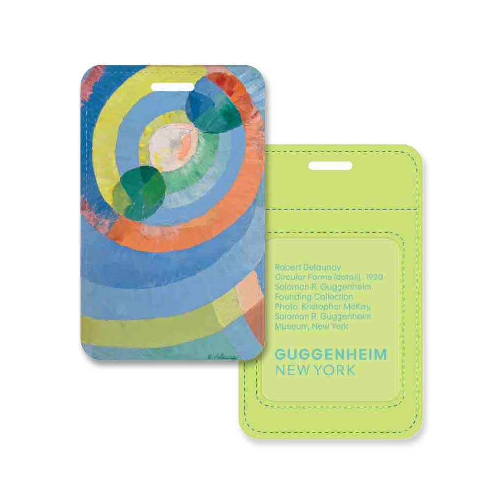 Two artistic luggage tags: the Delaunay, Circular Forms Luggage Tag with an abstract colorful pattern, and a light green vegan leather tag featuring "Guggenheim New York" in yellow at the bottom.