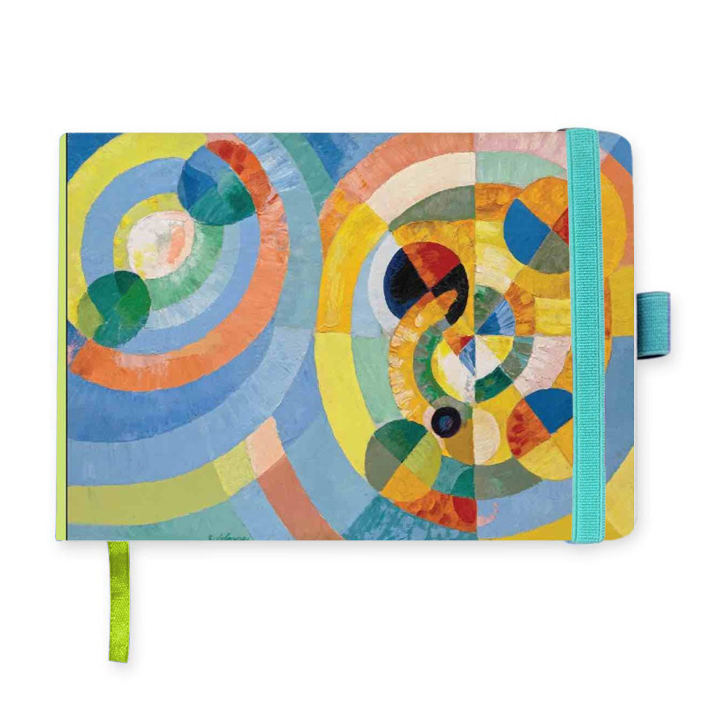 The Delaunay Circular Forms Notebook features a vibrant vegan leather cover with abstract circles and spirals in blue, green, yellow, orange, and red. It includes a turquoise elastic band, pen holder, and green ribbon bookmark for style and function.