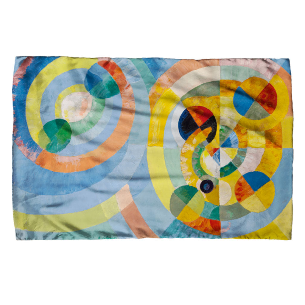 The Delaunay, Circular Forms Scarf features abstract textile art with overlapping circles in blue, yellow, green, orange, and red tones, creating a vibrant geometric pattern—perfect for a striking accessory.