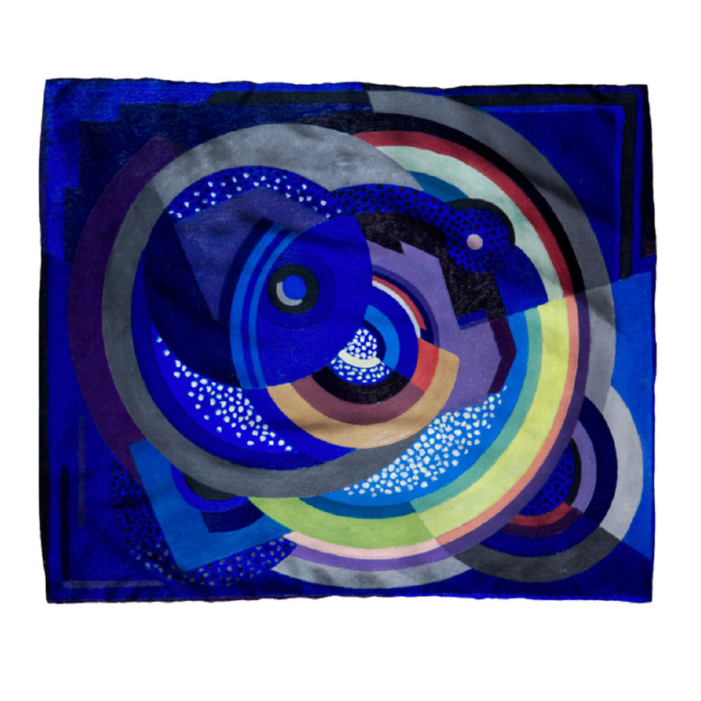 The Jellett Painting Scarf features abstract overlapping circles and geometric shapes in vibrant hues on a dark blue background, inspired by Irish modern art and evoking the dynamic style of Mainie Jellett.