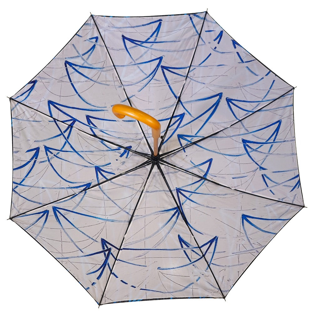 The Rashid Johnson Dual Sided Stick Umbrella, Untitled Seascape Drawing, features a transparent canopy with blue abstract sailboat patterns and a curved yellow handle for open artistic style.
