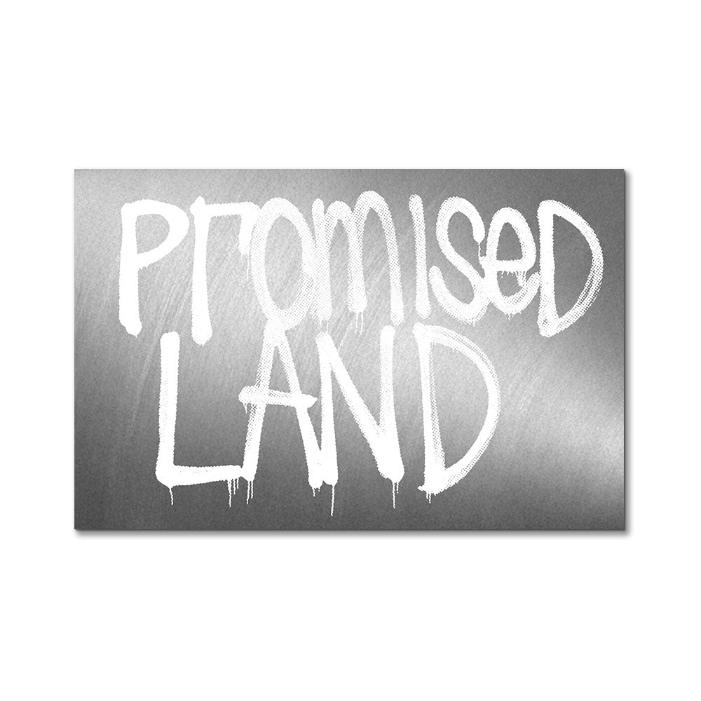 The Rashid Johnson Promised Land Sticker features a metallic background with "PROMISED LAND" in large, white, graffiti-style letters—some strokes dripping paint. Size: 4 x 2.6 inches.