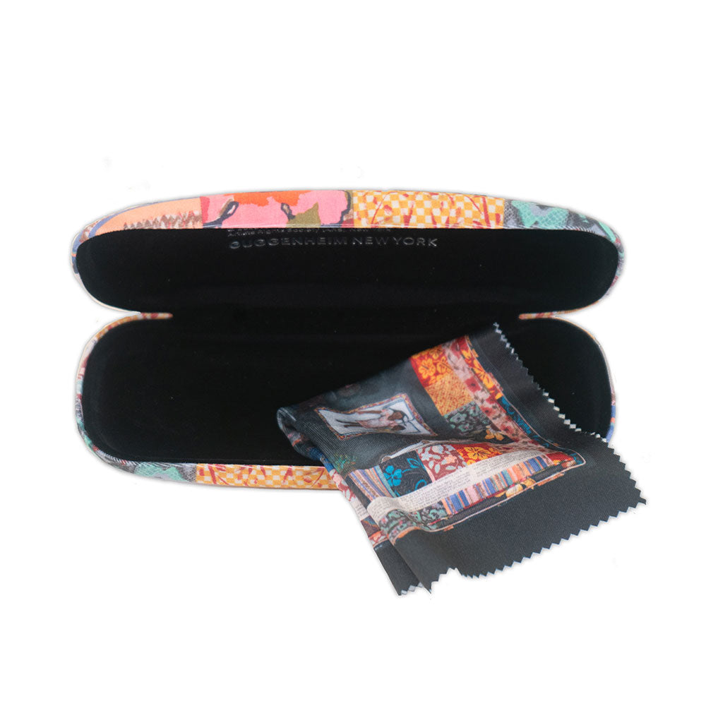 The Faith Ringgold Tar Beach Eyeglass Case with Cloth features a vibrant patchwork design and includes a matching microfiber cloth. The plastic case sits open, showing its black interior with the cloth draped over the edge.