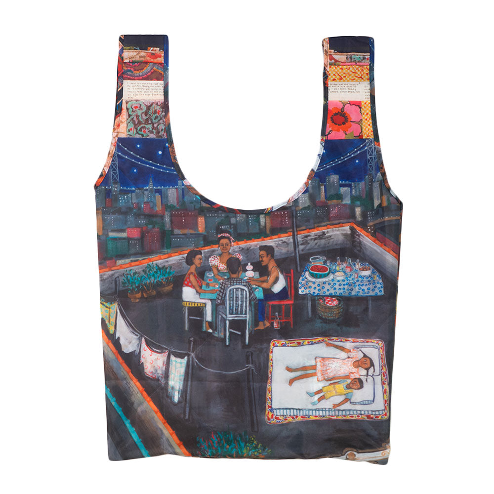 The Faith Ringgold Tar Beach Foldable Tote Bag is a reusable RPET bag with vibrant artwork of rooftop dining, city buildings at night, and a child on a mat. Size: 16" x 26".