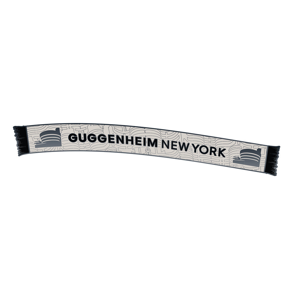 A Guggenheim Museum World Cup Scarf Magnet in white and black with abstract lines and building icons on each end.