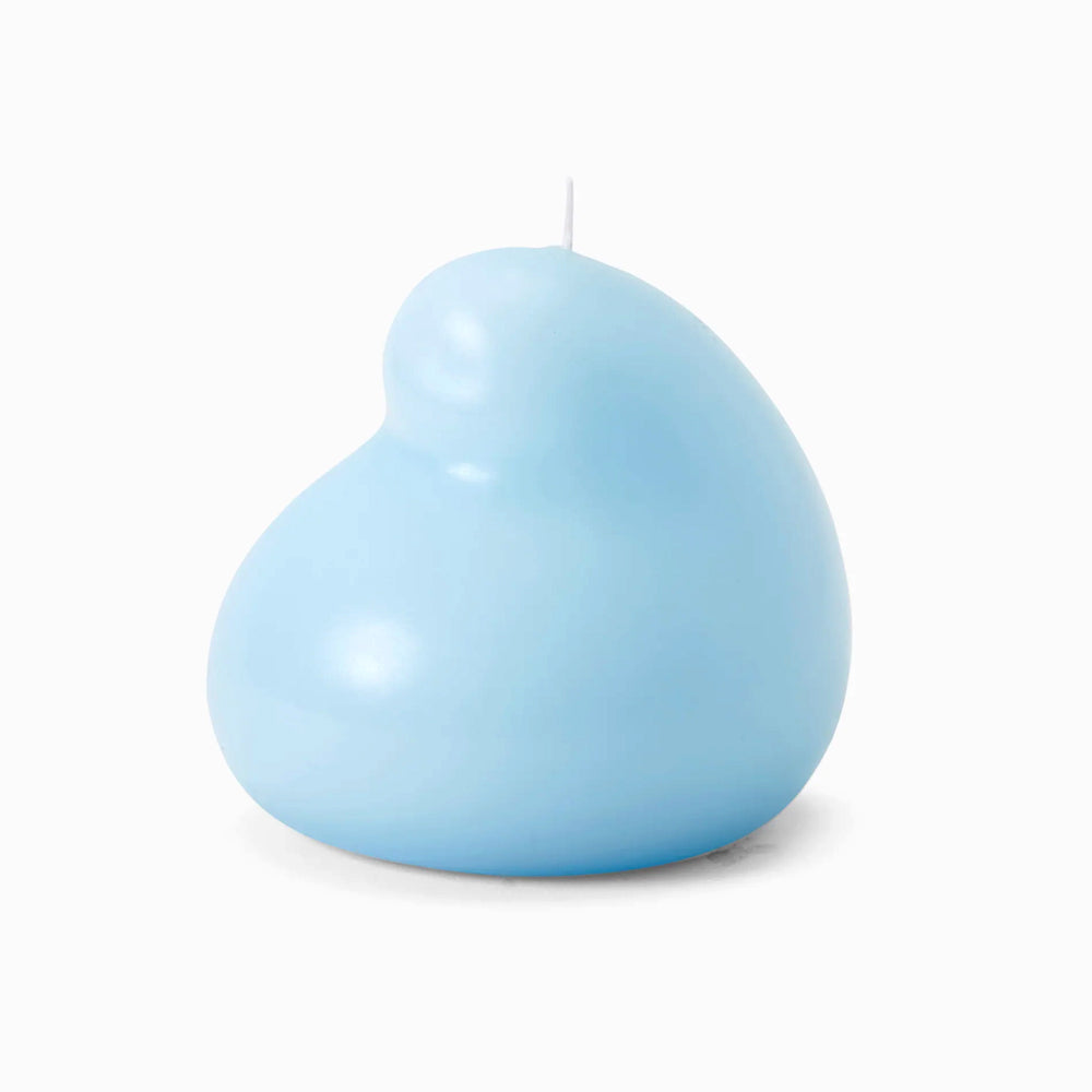 The Blue Goober Candle features an artful, abstract light blue shape with a smooth, rounded surface. Made from unscented paraffin wax, it has a short white wick and is displayed against a plain white background.