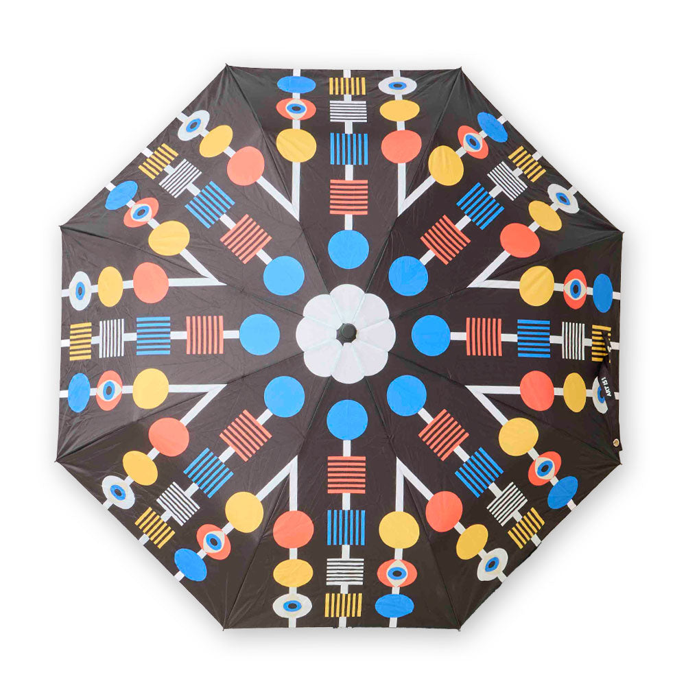 The Guggenheim Museum Eye Collection Travel Umbrella features bold geometric art, making it a stylish NYC accessory.