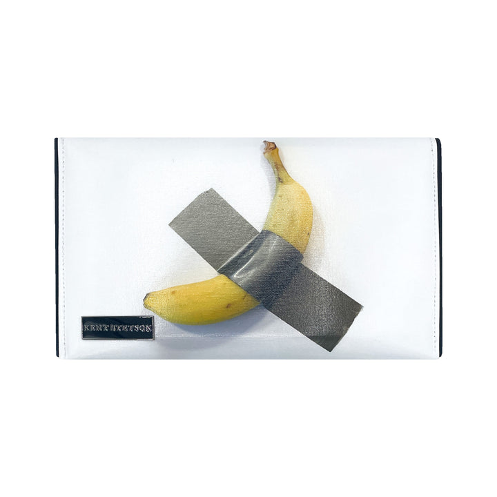 The Banana Pop Art Clutch by Guggenheim Museum features a quirky banana X-taped to a white background with a small label.