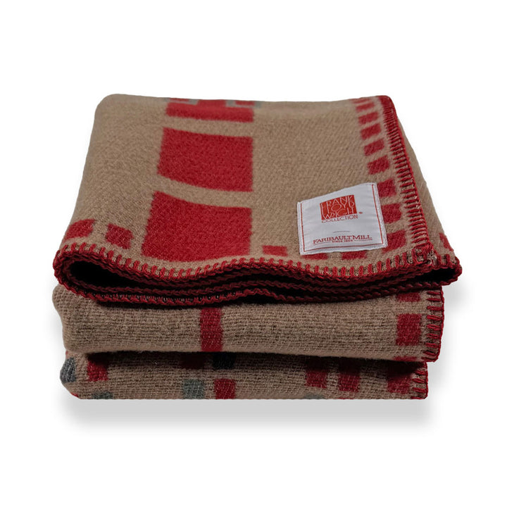 Guggenheim Museum Frank Lloyd Wright Hollyhock House wool throw, tan with red patterns and stitched label on white.