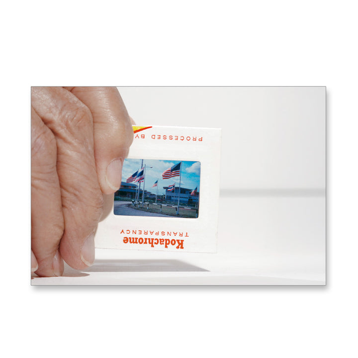 A hand displays a Guggenheim Taryn Simon Slides Post Card—an homage to conceptual photography and American themes.
