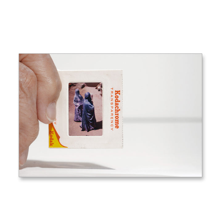 A hand holds a Kodak slide, evoking the Guggenheim Museum Taryn Simon Slides Post Card Set’s conceptual artistry.