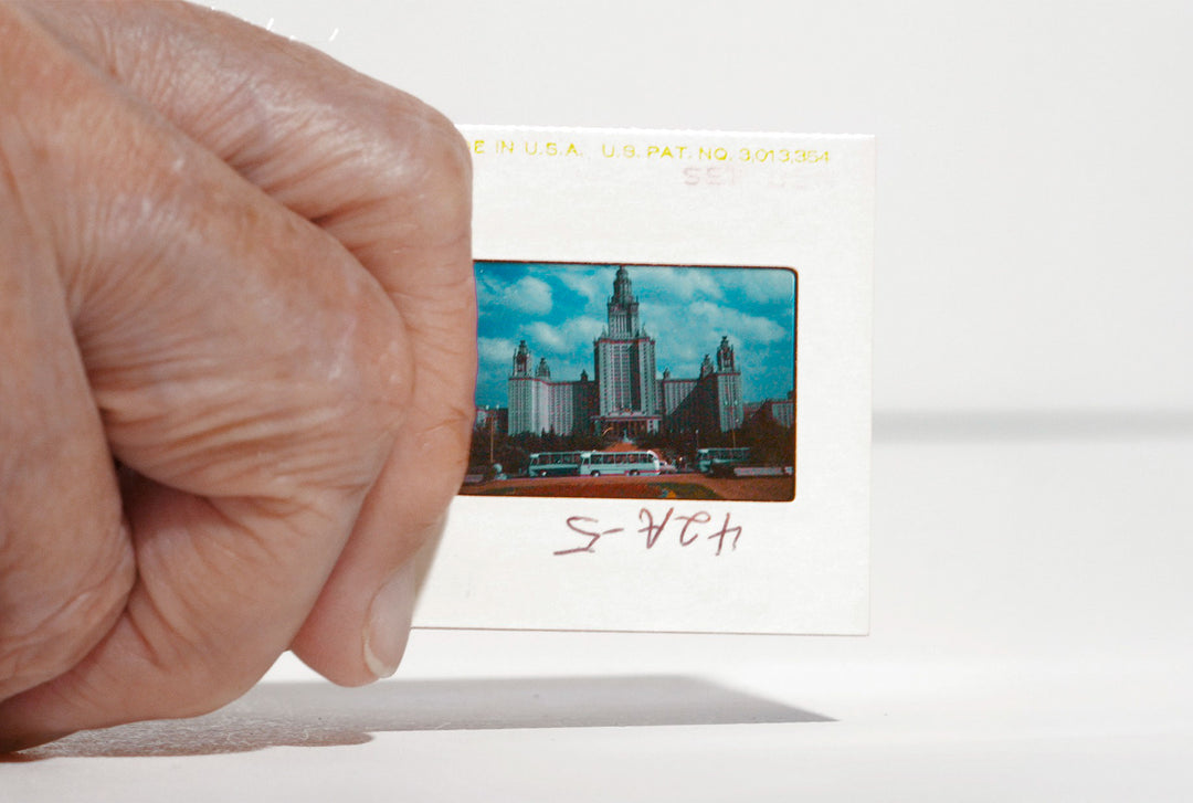 A hand holds a Taryn Simon Slides Post Card from the Guggenheim Museum, showcasing conceptual photography.