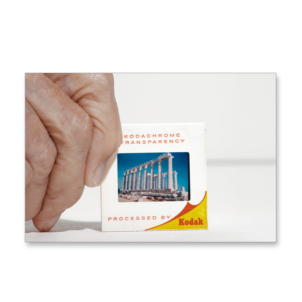 A hand holds a Guggenheim Museum Taryn Simon Slides Post Card, inspired by her conceptual photography style.