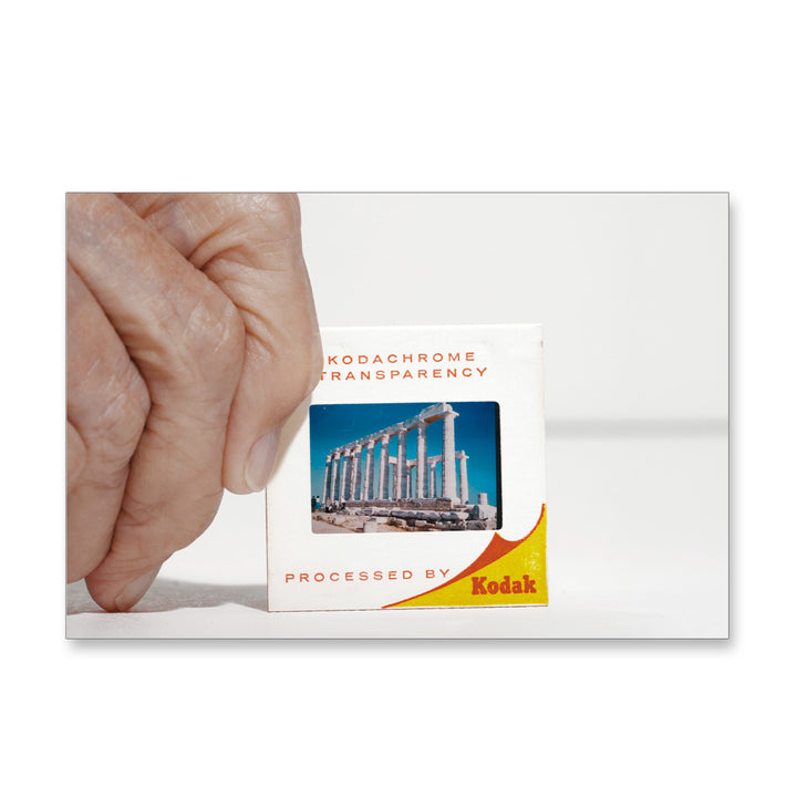 A hand holds a Guggenheim Museum Taryn Simon Slides Post Card, inspired by her conceptual photography style.
