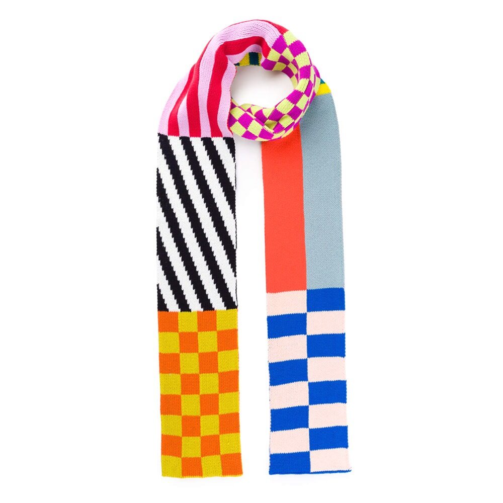 The Pattern Patch Skinny Knit Scarf features bold checkered, striped, and solid patterns in pink, yellow, orange, blue, black, and white. Made from soft acrylic yarn and machine washable for easy care.