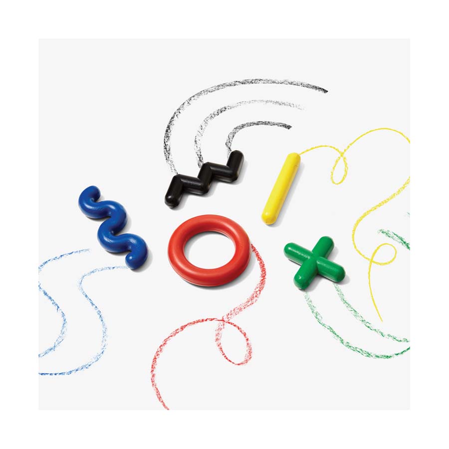 Five Doodle Crayons—blue squiggle, black zigzag, yellow cylinder, red ring, and green cross—made from paraffin wax are arranged on white paper, each leaving matching curving crayon marks.