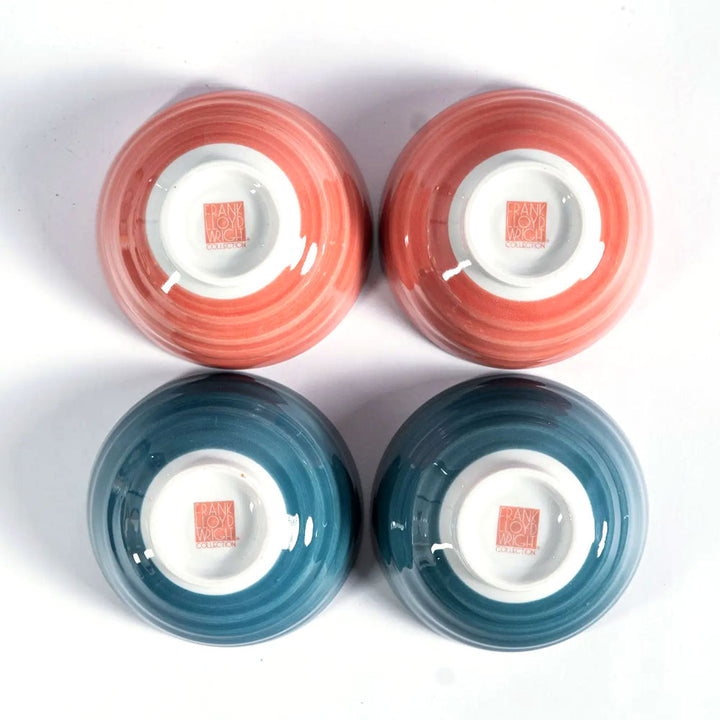 Four ceramic bowls—two coral, two blue—reflect nature in the Guggenheim Museum Frank Lloyd Wright Rice Bowl Set.