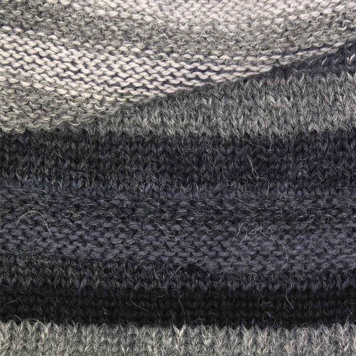 Close-up of the Colorado Alpaca Beanie in Ivory, featuring horizontal stripes in gray and ivory shades. The Baby Alpaca yarn’s soft texture and detailed stitch pattern are visible. One size fits most.
