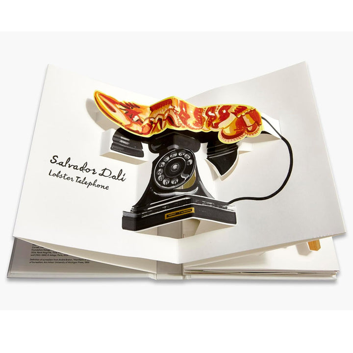 Pop-Up Surrealism is an open pop-up book featuring a 3D scene of Salvador Dalí’s Lobster Telephone—a black rotary phone topped by a vivid orange lobster—showcasing classic surrealist art in interactive form.