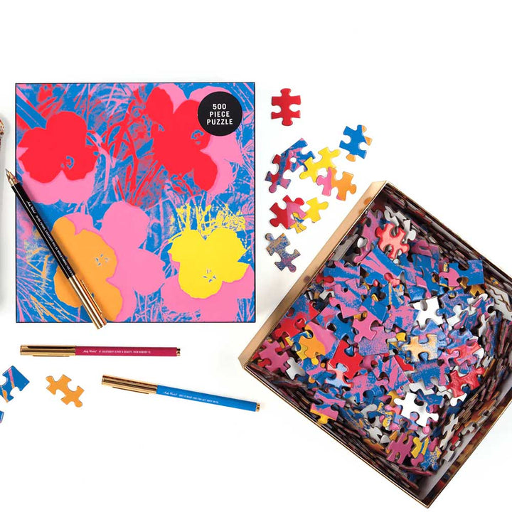 The Guggenheim Museum Andy Warhol Flowers 500 Piece Jigsaw Puzzle, box and pencils scattered on a white surface.