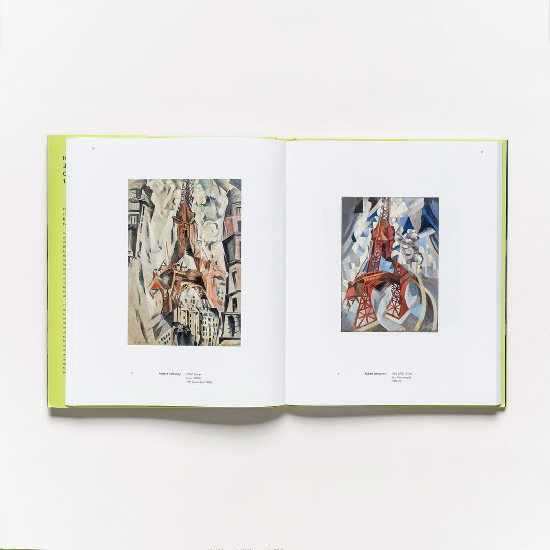 An open copy of "Harmony and Dissonance: Orphism in Paris, 1910–1930" displays two abstract Eiffel Tower paintings—muted tones on the left, bold reds and blues on the right—its light green spine complementing this tribute to Parisian art.