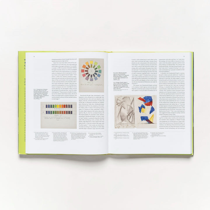 An open copy of *Harmony and Dissonance: Orphism in Paris, 1910–1930* shows text and four images: a color wheel, grayscale bar, pencil sketch, and an Orphism-inspired abstract with red, blue, and yellow shapes on white.