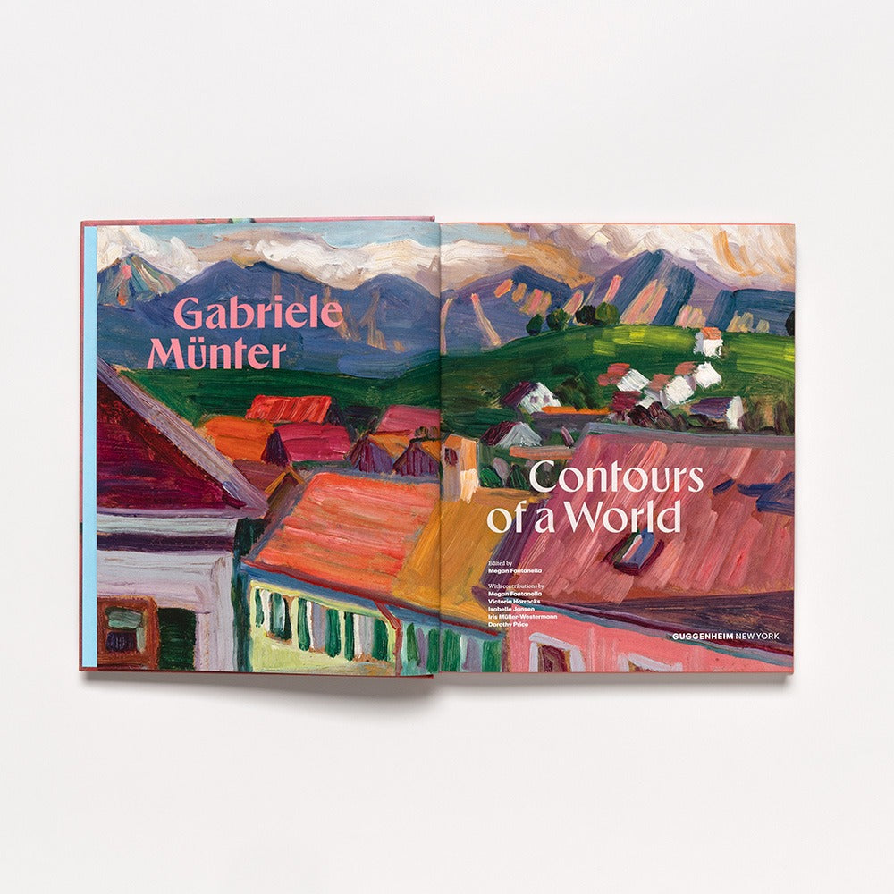 An open hardcover art book, "Gabriele Münter: Contours of a World," displays a vivid village painting with mountain backdrops—an inspiring 2025 addition for art lovers.