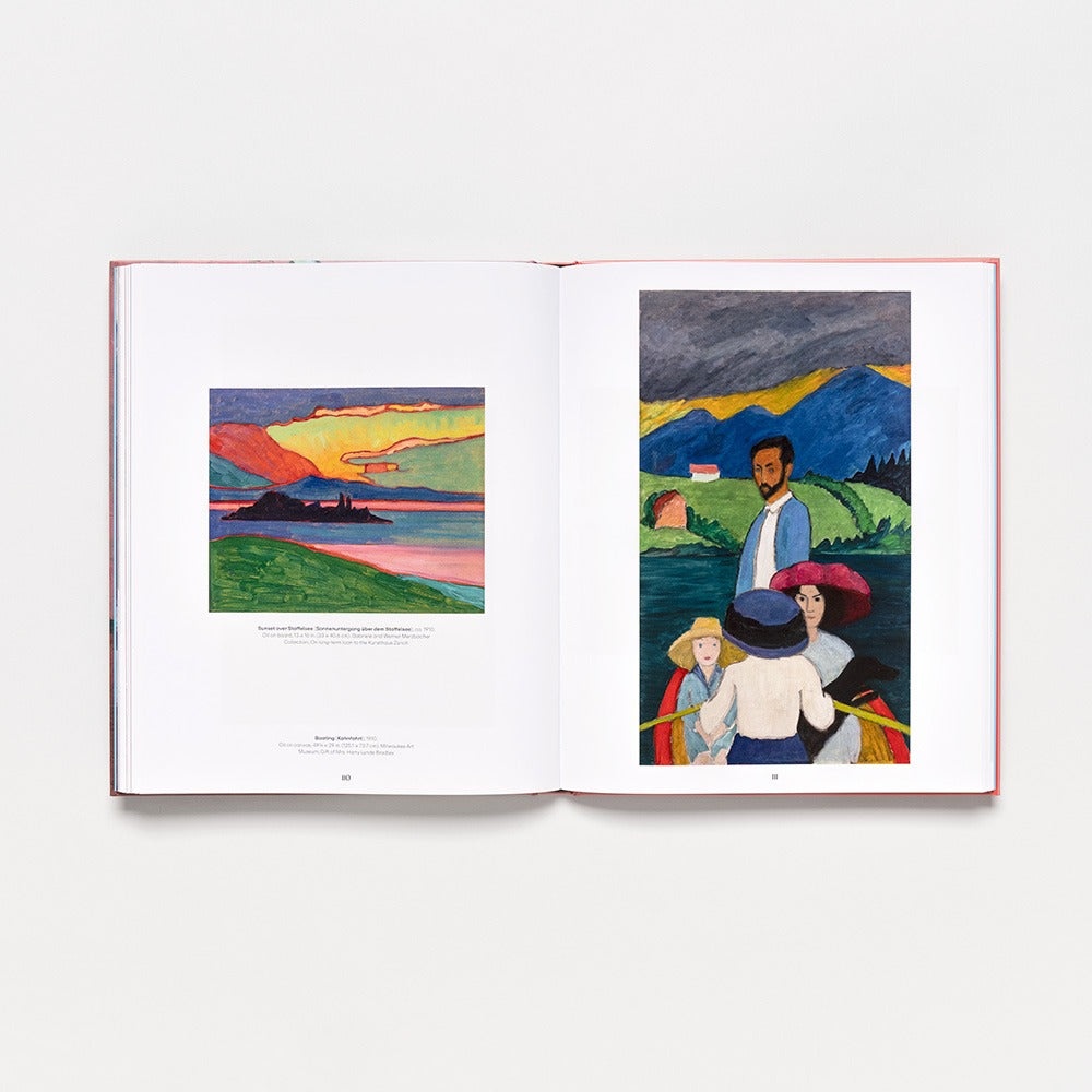 An open hardcover art book, "Gabriele Münter: Contours of a World," displays two colorful paintings—one of a sunset lake landscape and another featuring figures outdoors with mountains and a house in the background from the 2025 collection.