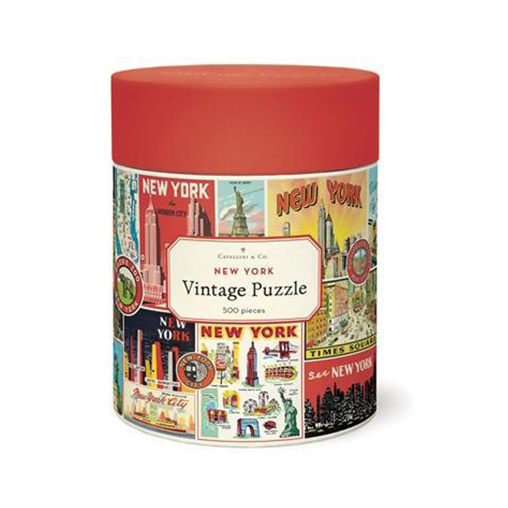 A cylindrical box with a red lid holds the Guggenheim Museum NYC Collage 500 Piece Puzzle of iconic New York scenes.