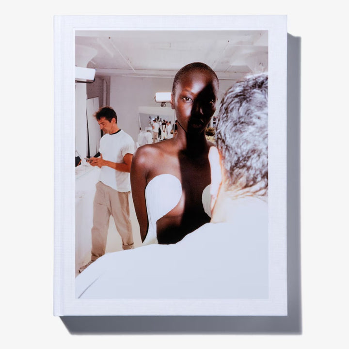 A photo of a dark-skinned fashion model in a strapless white garment, with two men nearby, appears on the cover of the limited-edition book Alaïa by Seklaoui.