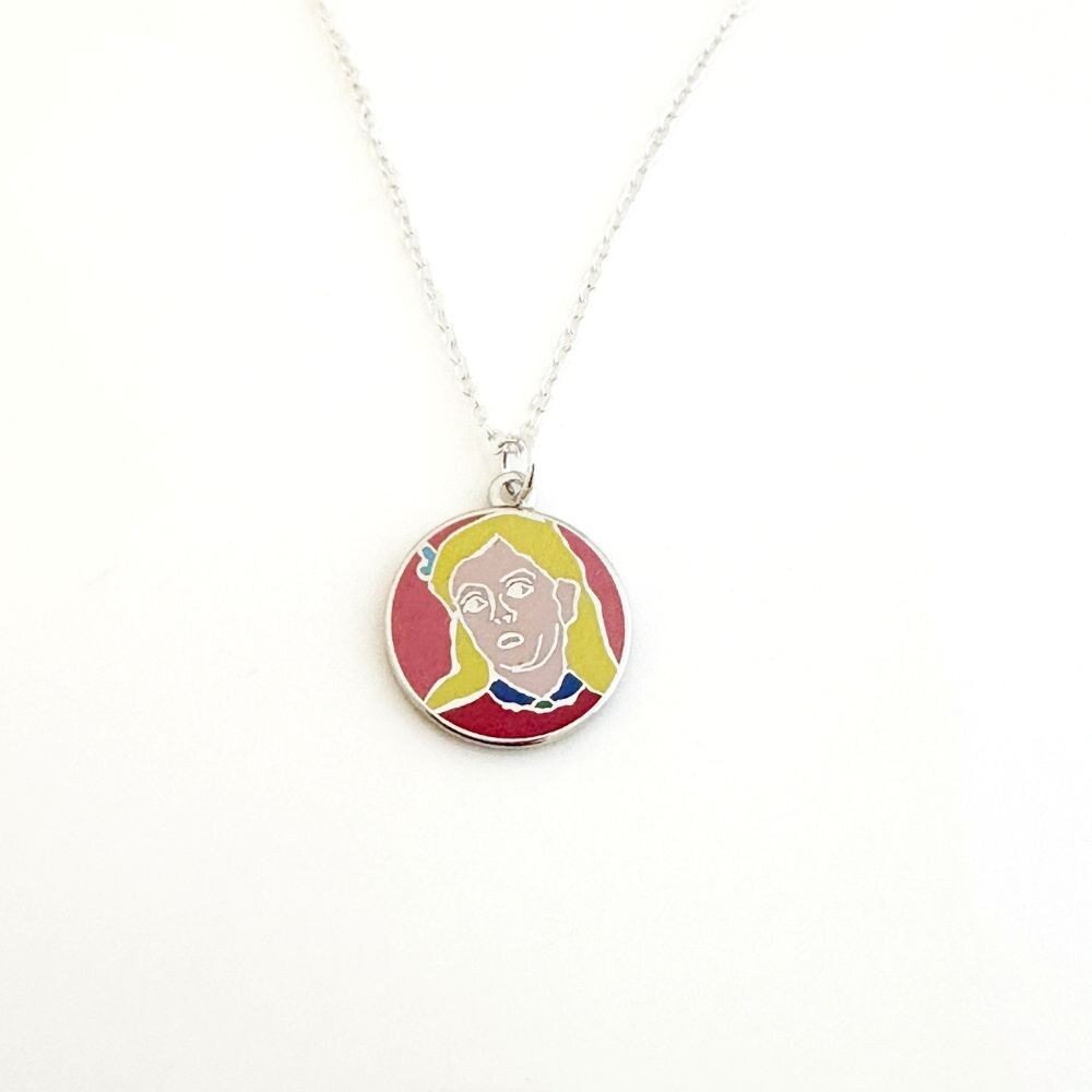 The Gabriele Münter, Head of a Young Girl Necklace is a silver-plated piece with a round pendant showing an abstract portrait of a light-skinned girl with yellow hair on a pink background, hanging from a delicate chain with lobster clasp.